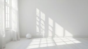 白い部屋に差し込む窓の影と、静かに置かれた白い花瓶
